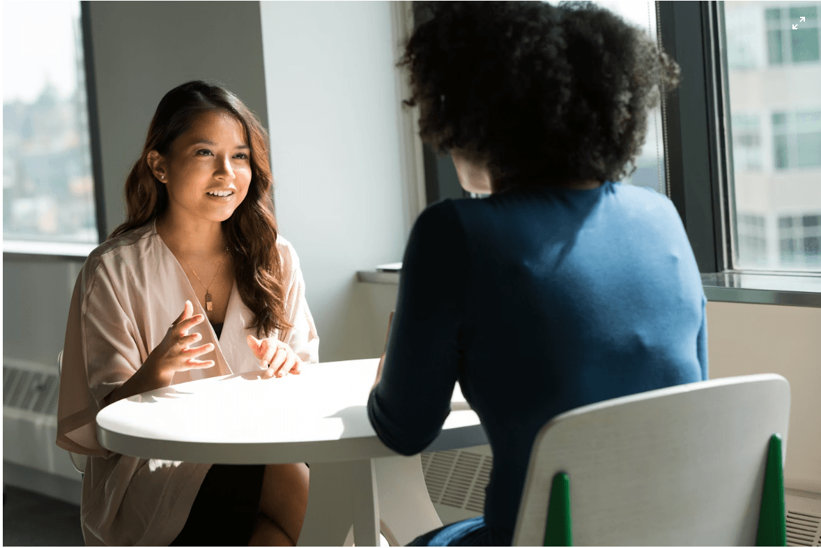 Two women talking across a table during a career counseling session